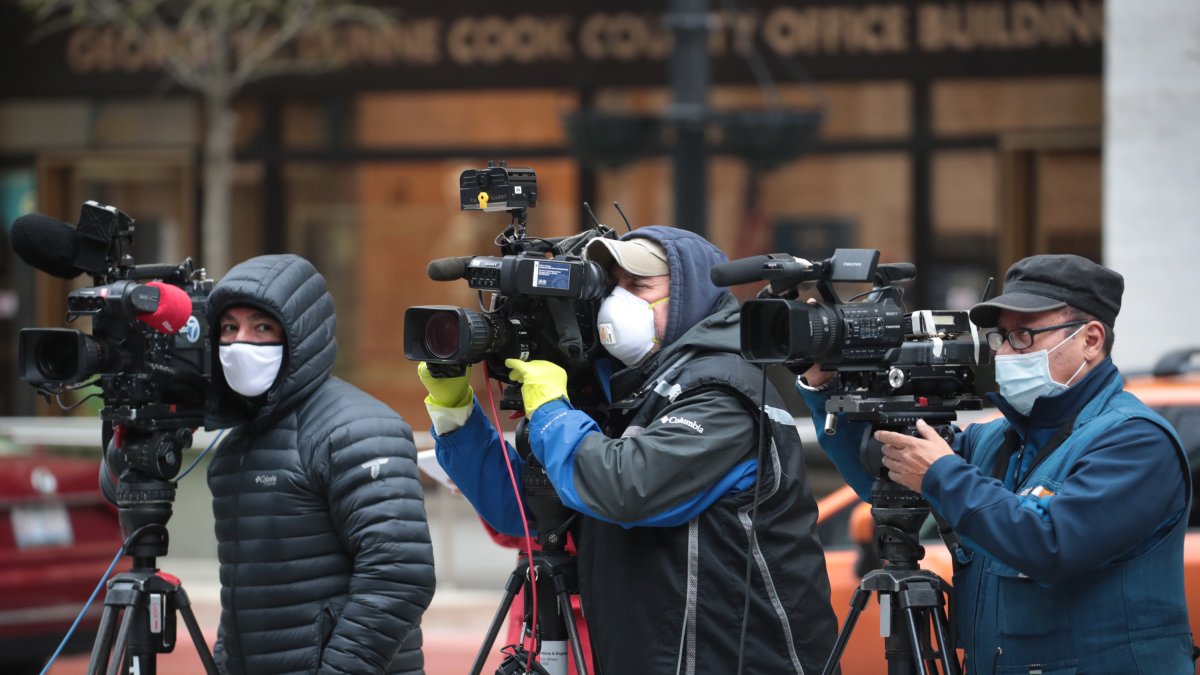 Periodista con máscaras documentan una protesta en la que los manifestantes pidieron que se suspenda los pagos de la renta debido al coronavirus en Chicago, EE. UU. 