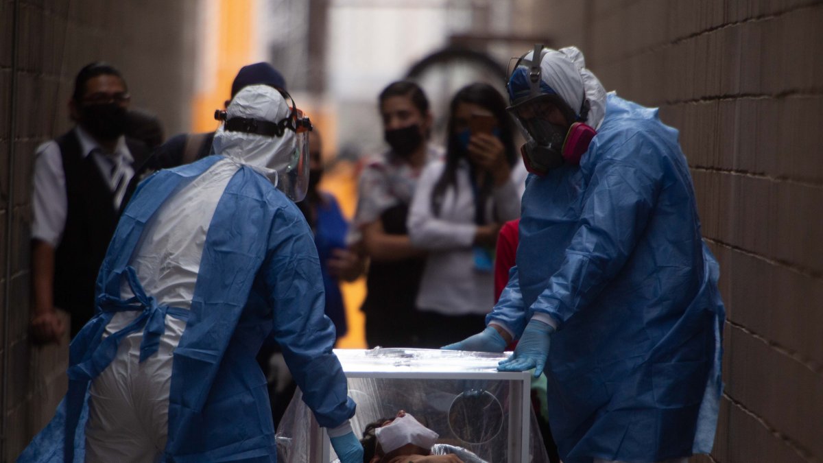 Un hombre es conducido con todas las medidas de bioseguridad a una ambulancia en Morelia, México