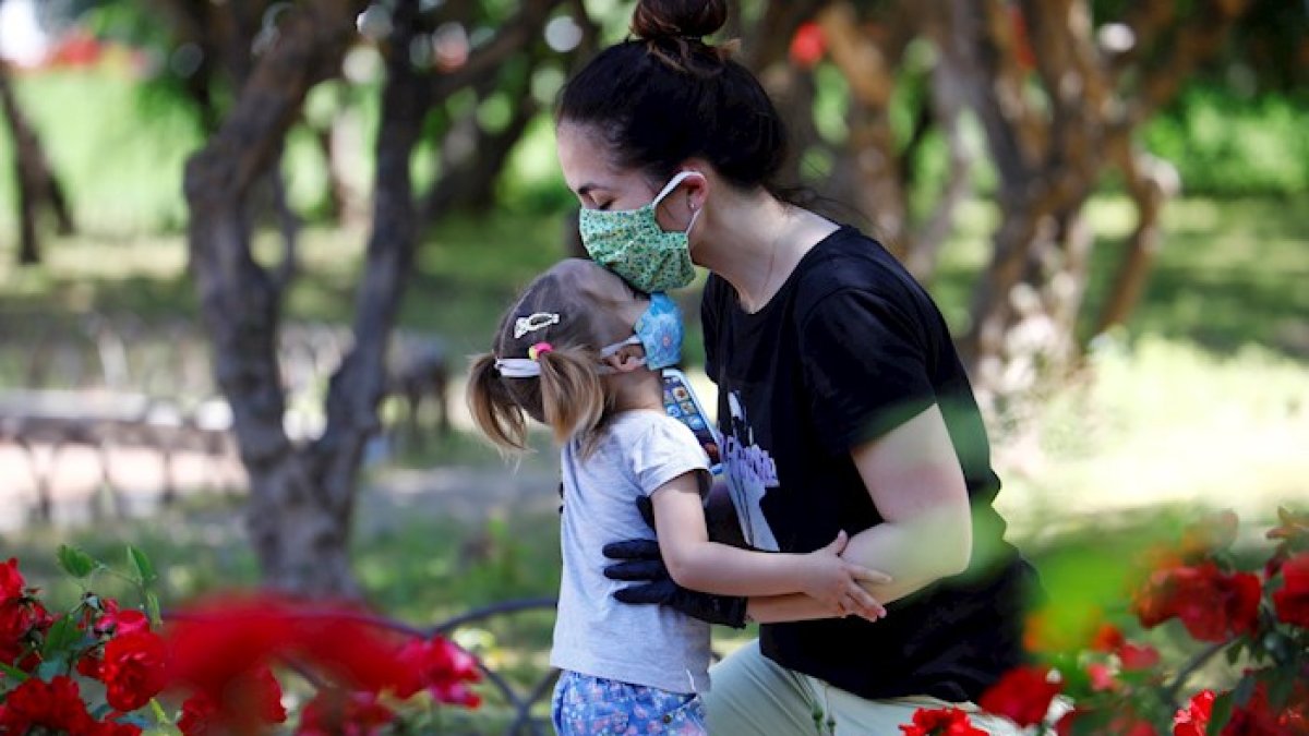 Una mujer deja un beso en la frente de su hija en un parque en Córdoba, sur de España.