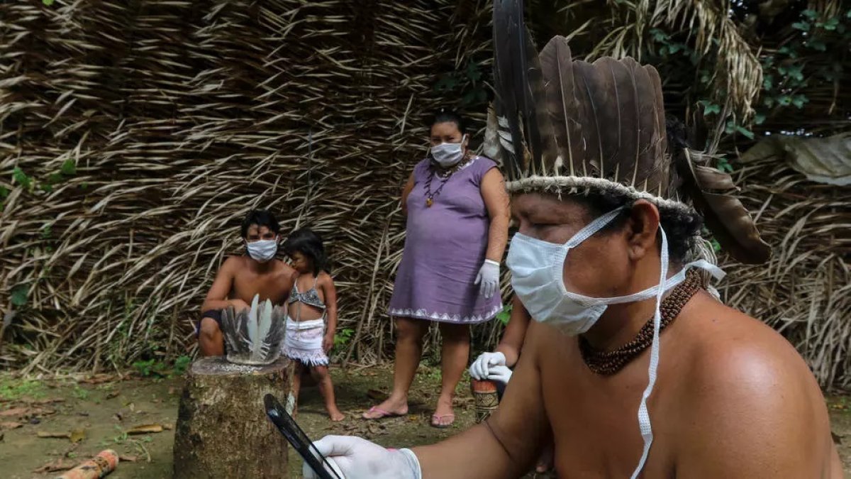 Brasil. Indígenas Sateré-Mawé usan un teléfono móvil para comunicarse con un médico en el estado de Sao Paulo para recibir orientación médica en medio de la pandemia del coronavirus.