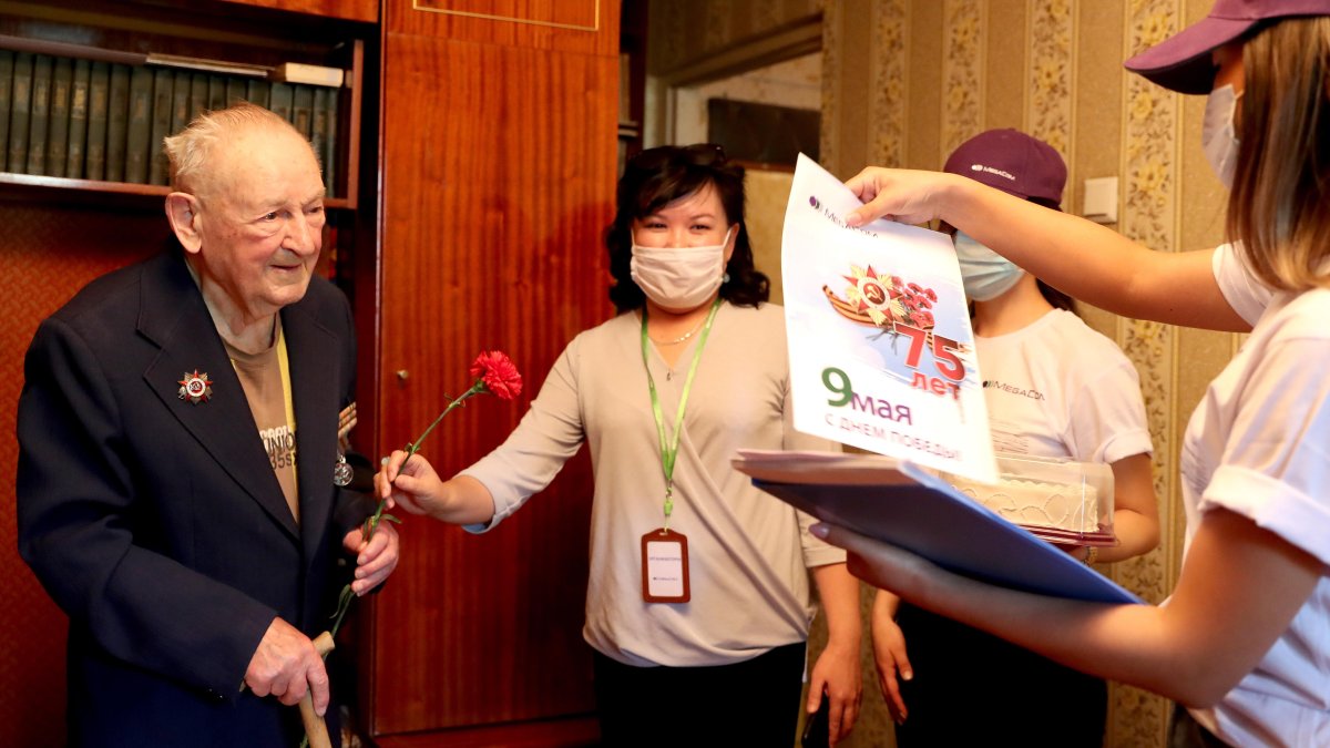 El veterano de la Segunda Guerra Mundial, Ivan Nikolaevich Golikov es recibido por los empleados de la empresa  Megacom para celebrar el Día de la Victoria en su casa en Bishkek, Kirguistán.