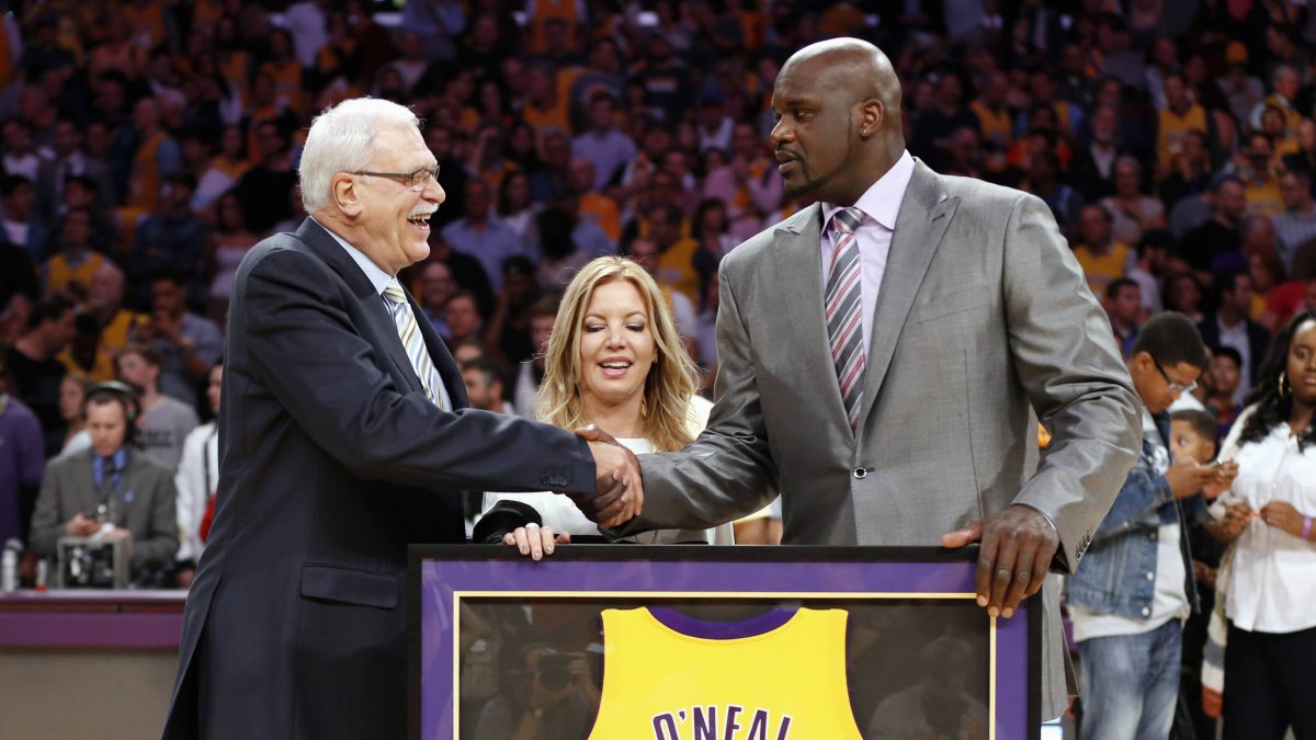Shaquille O'Neal (d)en una de sus últimas apariciones cuando recibió de manos del entrenador Phil Jackson la camiseta emblemática de los Lakers.