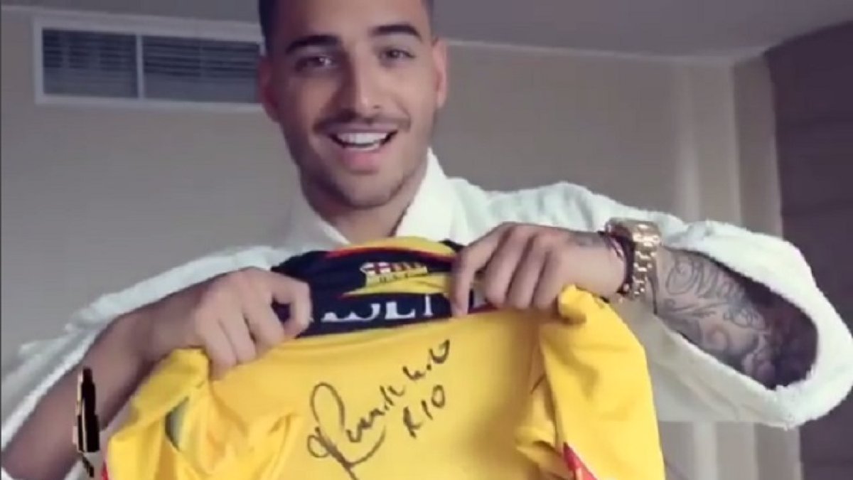 Maluma muestra una camiseta de Barcelona firmada por Ronaldinho.