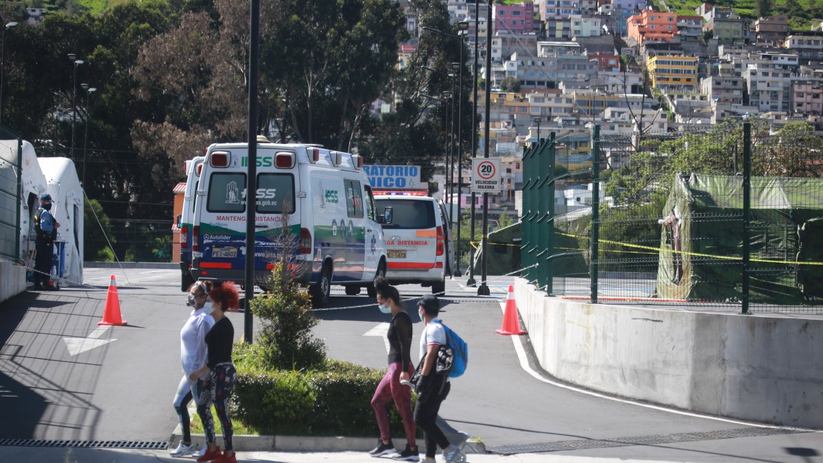 Un grupo de personas, protegidas con mascarillas, pasa frente al Hospital del IESS del Sur de Quito, este fin de semana.
