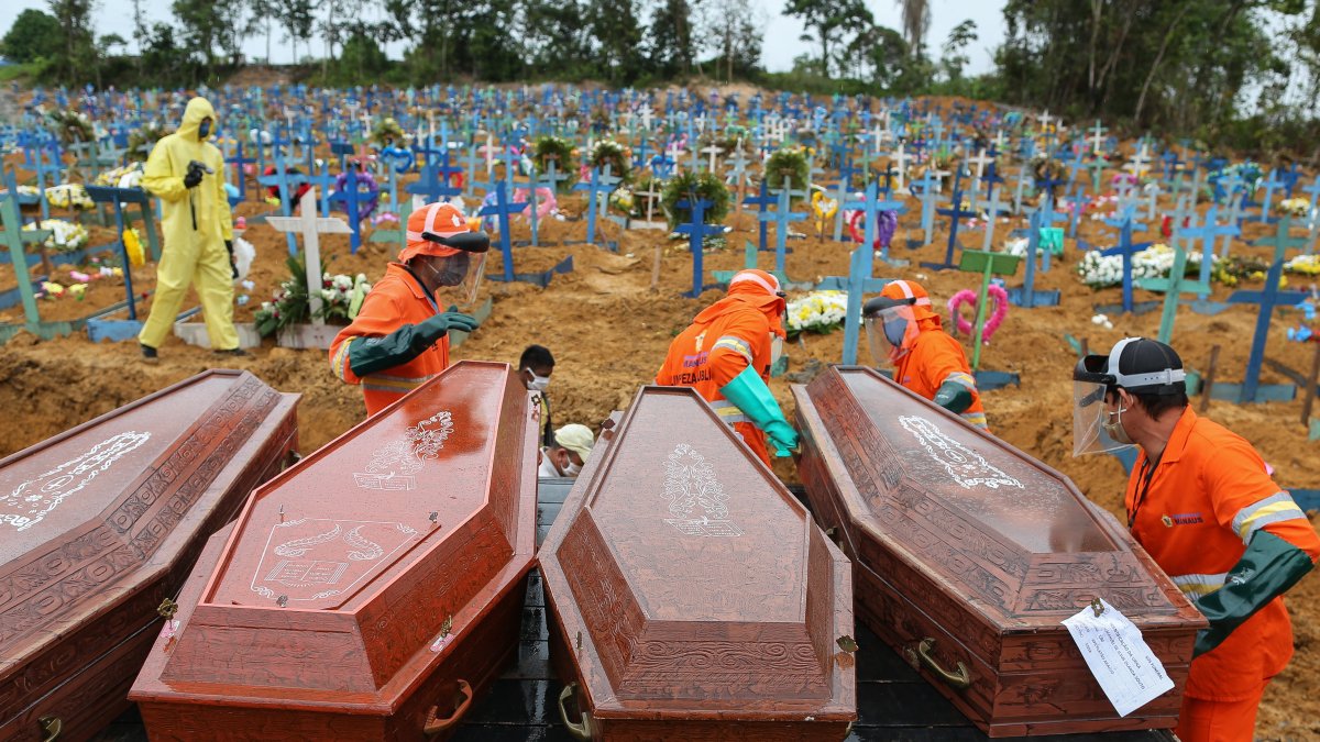 Sepultureros descargan ataúdes para ser enterrados en una fosa común en el cementerio Nossa Senhora en Manaos, Brasil. 