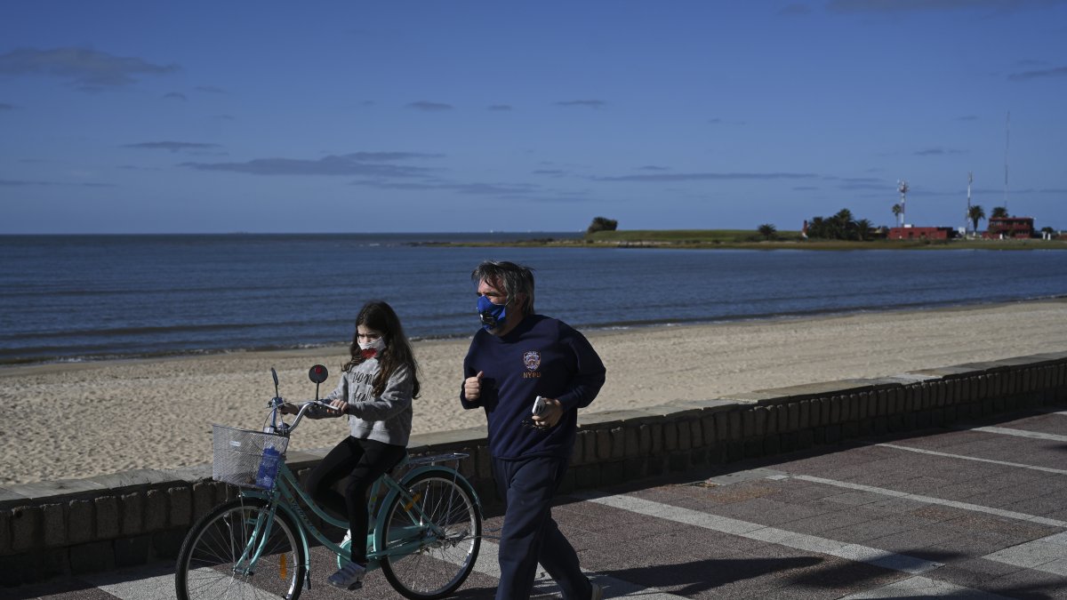 MONTEVIDEO. Un hombre pasea con su hija por una zona turística de esta capital latinoamericana, que nunca decretó una cuarentena general. Algo que sí sucedió con los países de su alrededor.