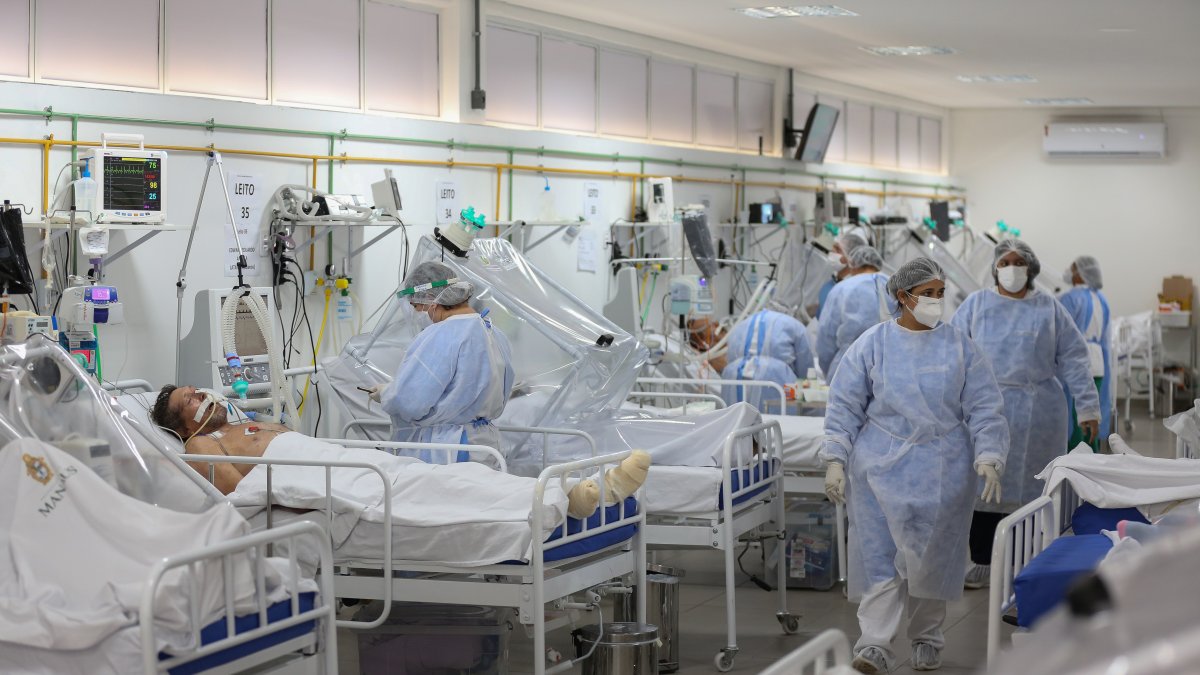 Trabajadores de salud cuidan de pacientes de la Unidad de Cuidados Intensivos para COVID-19 del Hospital Gilberto Novaes en Manaos