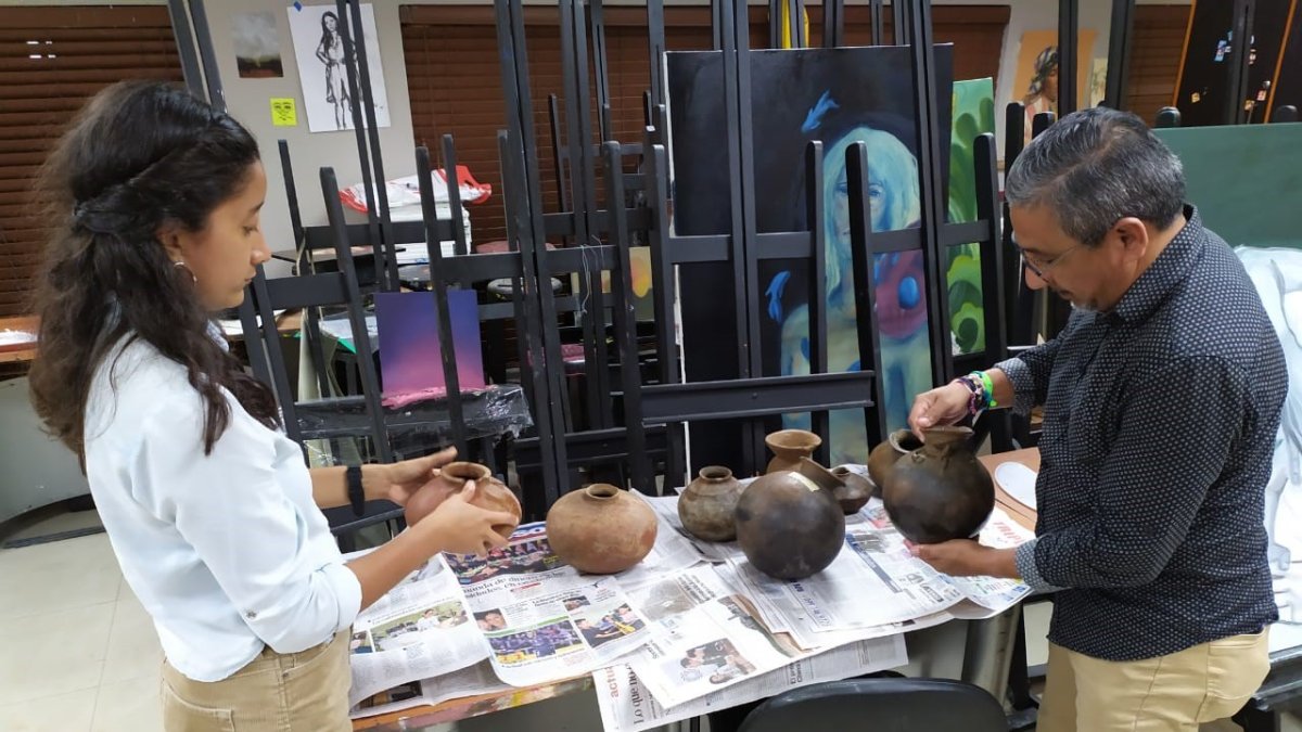 Enrique Palma Chenche selecciona junto a una estudiante las piezas de la casa comunal que servirán para el futuro museo.