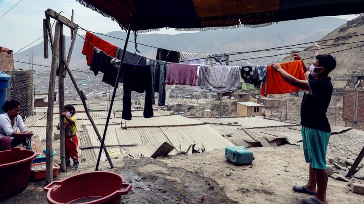 Protegidos con mascarillas, y en plena pandemia por coronavirus, habitantes del barrio pobre 