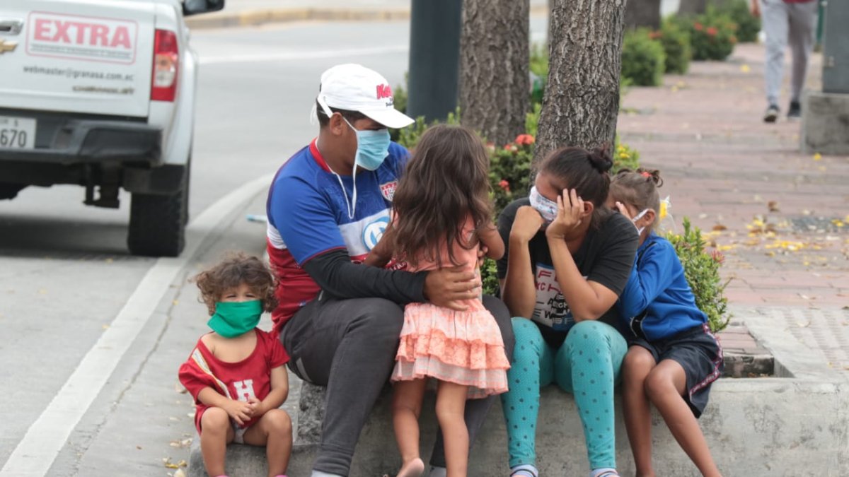 Riesgo. Un padre sale a las calles de Guayaquil con sus cuatro hijos, cuando el semáforo aún indica que se debe mantener el distanciamiento físico.