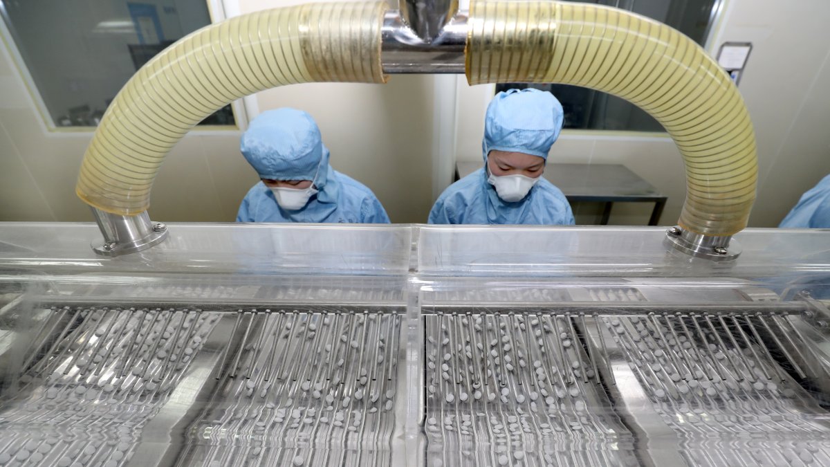 PEKÍN. Dos trabajadoras de una de las farmacéuticas en China, encargadas de la elaboración de cloroquina.