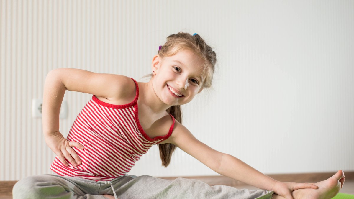 Niña realiza ejercicios de estiramientos.
