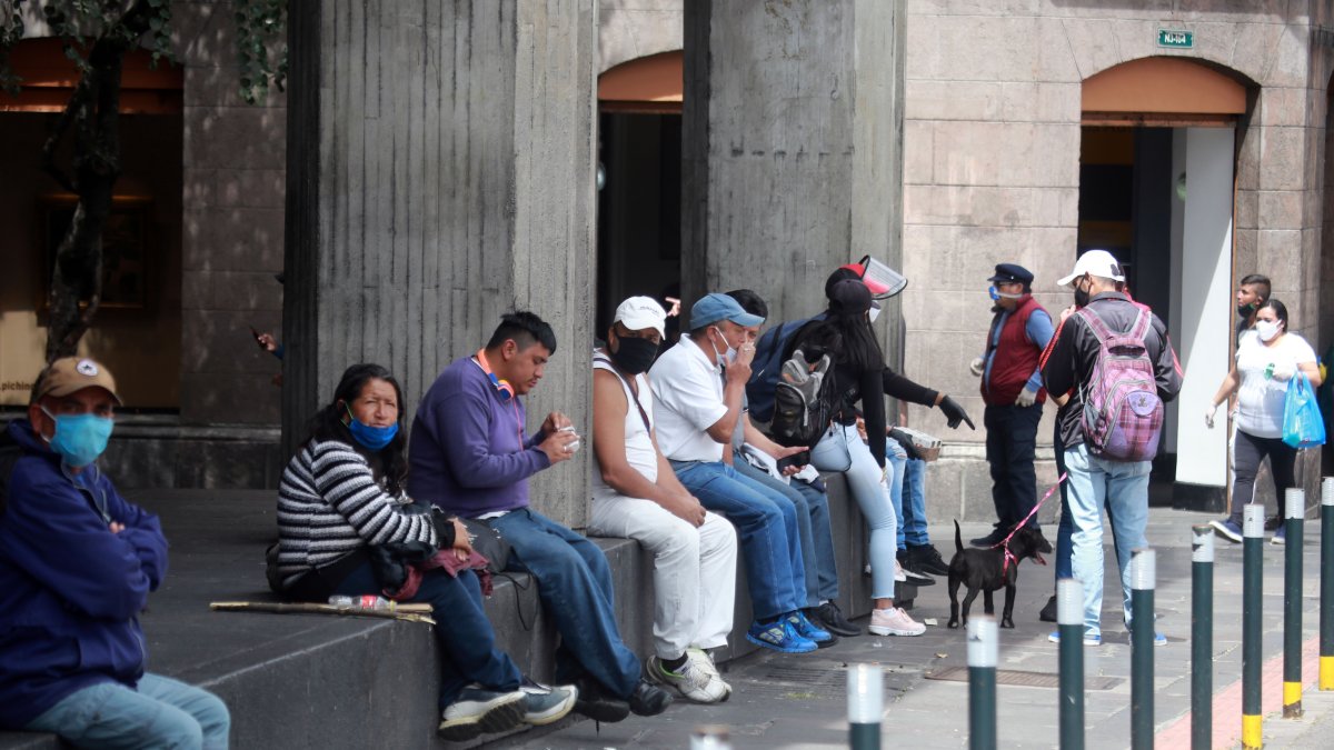 Ciudadanos en Quito usan medidas de seguridad como mascarillas al caminar por el Centro Histórico.