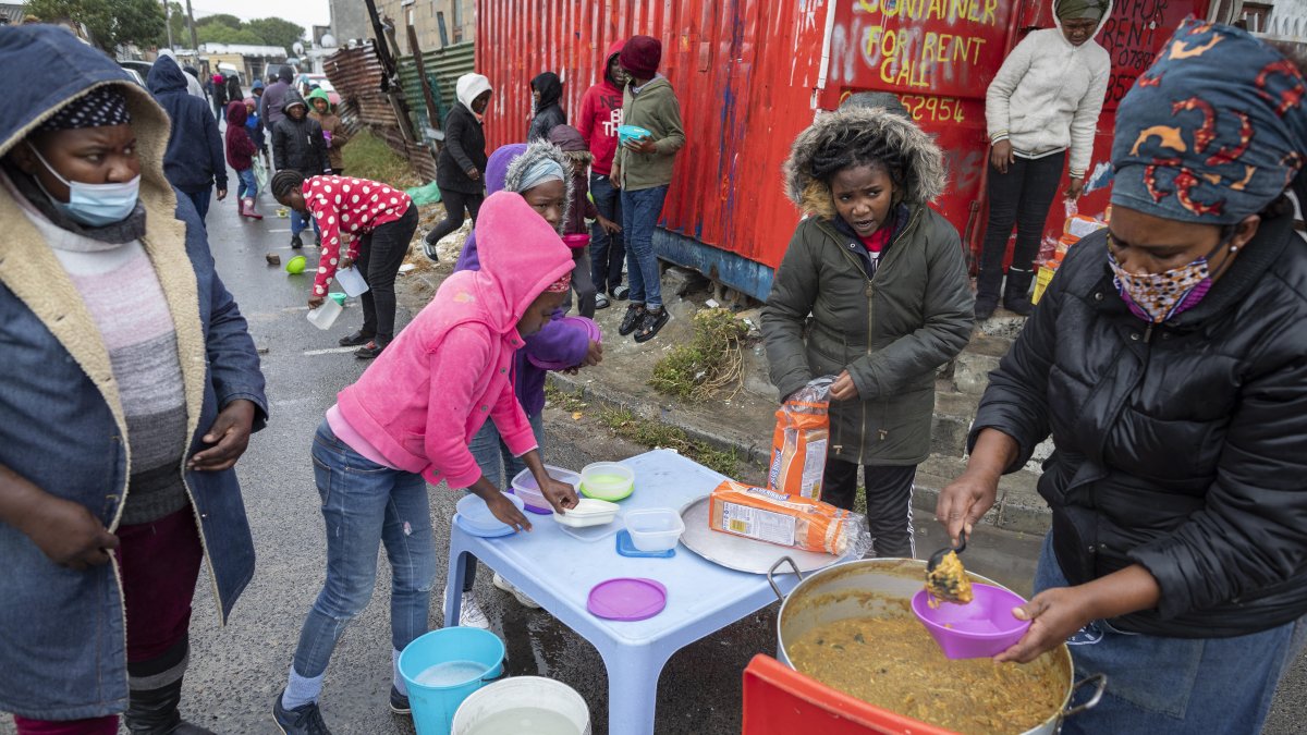 CIUDAD DEL CABO. Yandiswa Mazwana y otros ayudantes distribuyen alimentos del esquema de alimentación Masiphumelele Creative Hub dirigido por Yandiswa Mazwana en Masiphumelele,