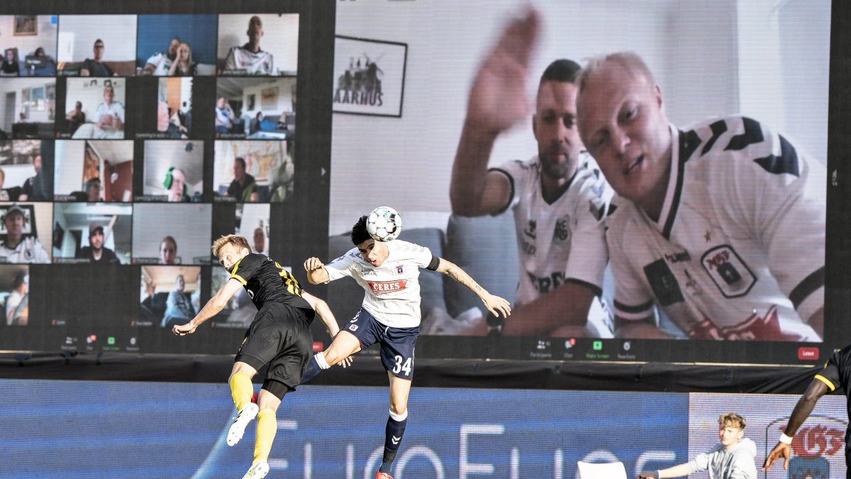 Los hinchas del Aarhus de Dinamarca miran el partido mediante Zoom. Los jugadores pueden ver sus reacciones en las pantallas colocadas junto a la cancha.
