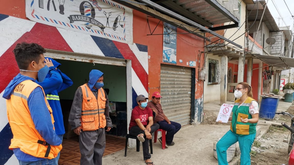 Un grupo de trabajadores escuchan las charlas del personal de salud.