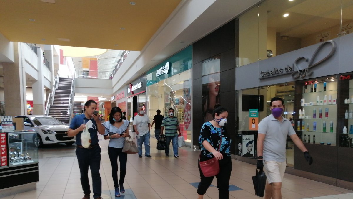 En un centro comercial de Guayaquil se observan a dos personas sin mascarilla.