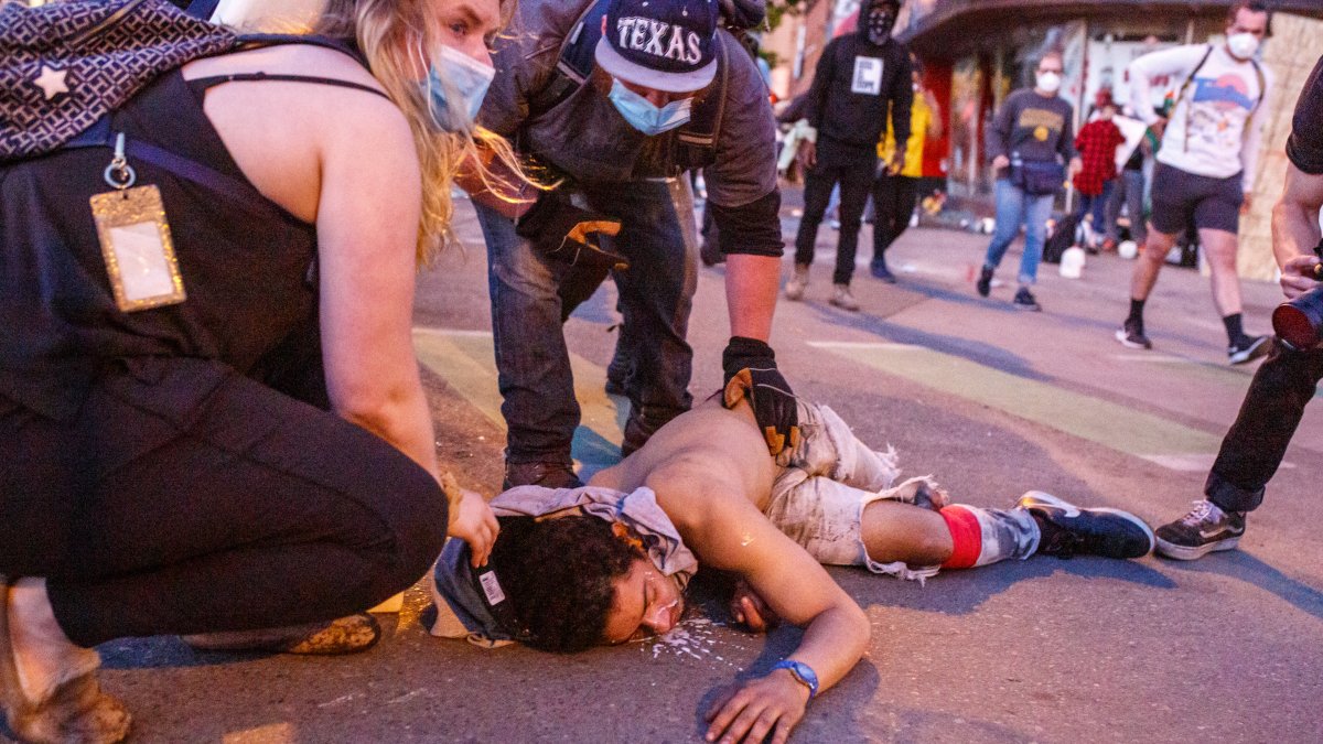 Manifestantes en Minneapolis asiste a una persona que cayó durante una protesta en la ciudad donde ocurrió el homicidio del ciudadano negro George Floyd en manos de un policía blanco.
