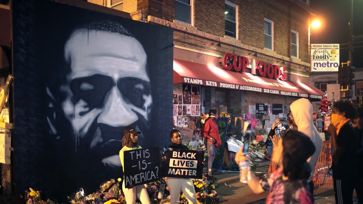 MINEÁPOLIS. Varias personas visitan en estos días el memorial que se levanta en el sitio en el que fue asesinado George Floyd la semana pasada.