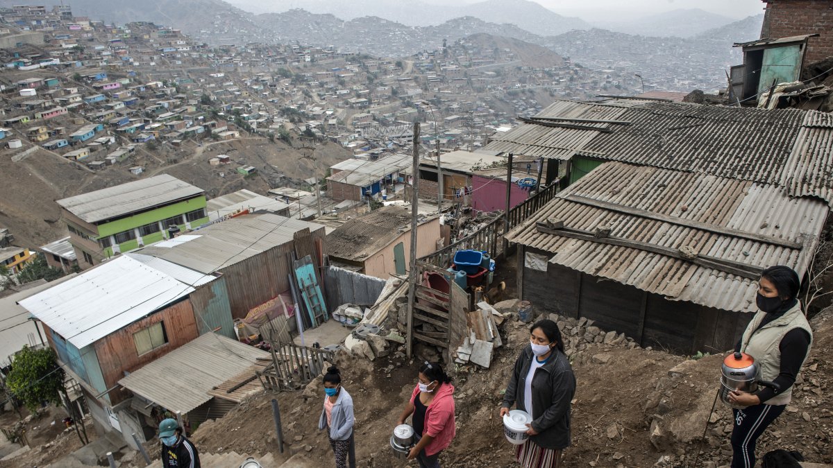 Un grupo de mujeres hacen cola para recibir algo de agua en el barrio Pamplona Alta, una de las zonas más pobres de Lima, capital de Perú.