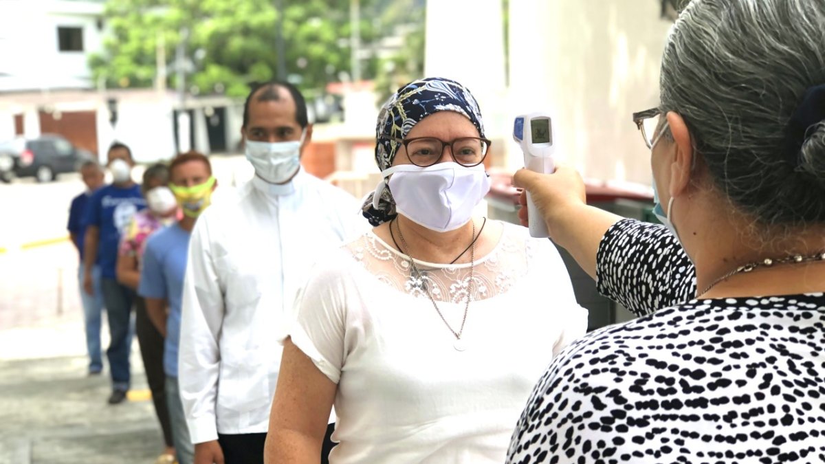 Salud. Los feligreses en columna esperan para cumplir el protocolo de prevención.