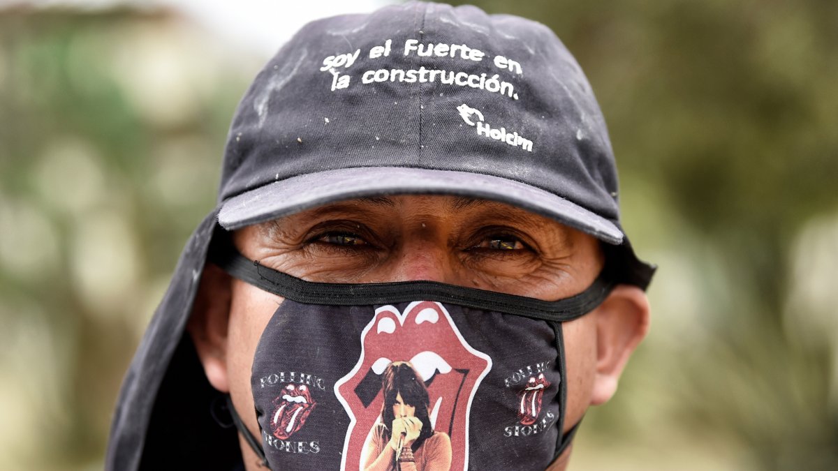 En México, un obrero de construcción usa una mascarilla con motivos de la mítica banda de rock Rolling Stones.