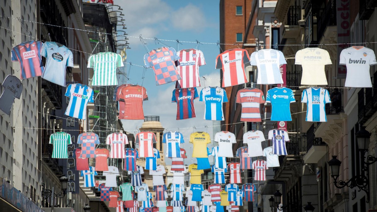 Camisetas de distintos equipos de fútbol adornan ya las calles de Madrid anunciando la reanudación de la competición de la liga profesionales tras el parón por la pandemia.