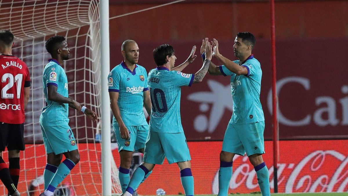 Lionel Messi festeja con Luis Suárez su anotación contra el Mallorca en el regreso a las canchas