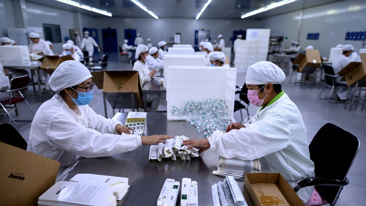 SHENYANG. Trabajadores empaquetan medicinas contra la rabia en un laboratorio de la compañía Yisheng Biopharma, donde se investiga el desarrollo de una vacuna para el COVID-19.