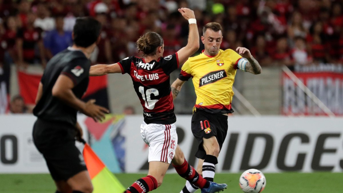 Filipe Luis (i) de Flamengo disputa el balón con Damian Díaz de Barcelona en uno de los últimos partidos de la Copa Libertadores disputados en marzo pasado.