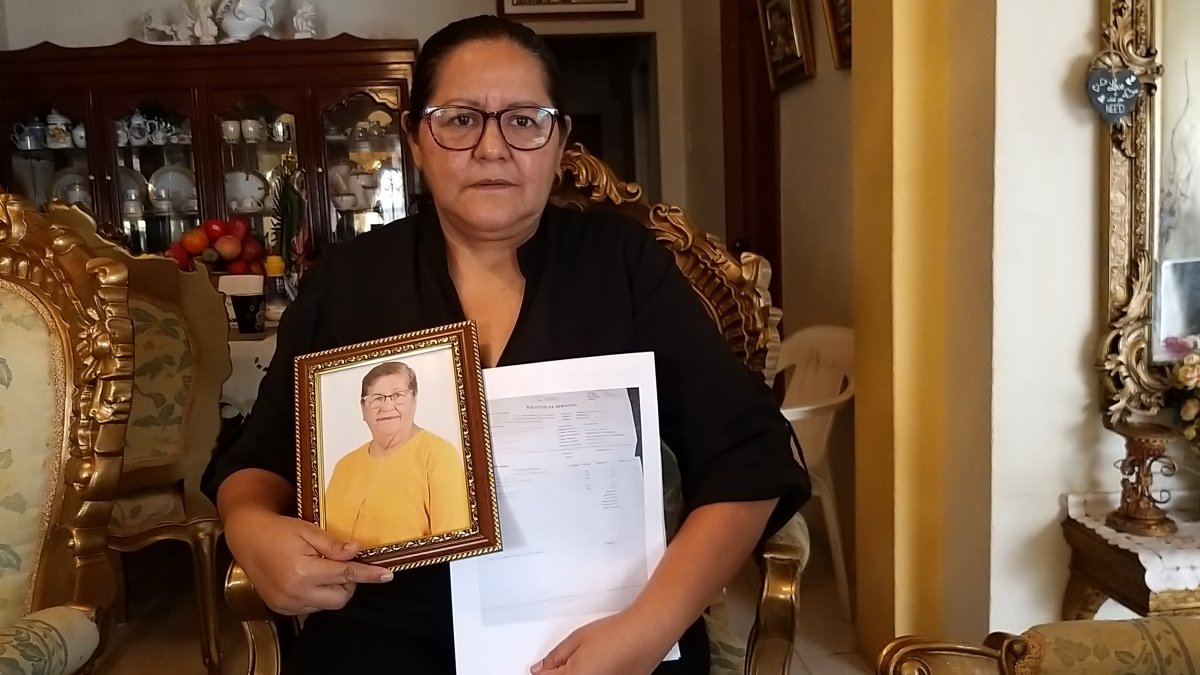 Elsa Maldonado sostiene un retrato de su madre y los papeles de defunción.