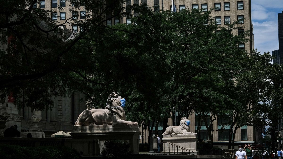 NUEVA YORK.Las estatuas de leones de mármol en la entrada de la Biblioteca Pública de la Gran Manzana, están adornadas con máscaras.
