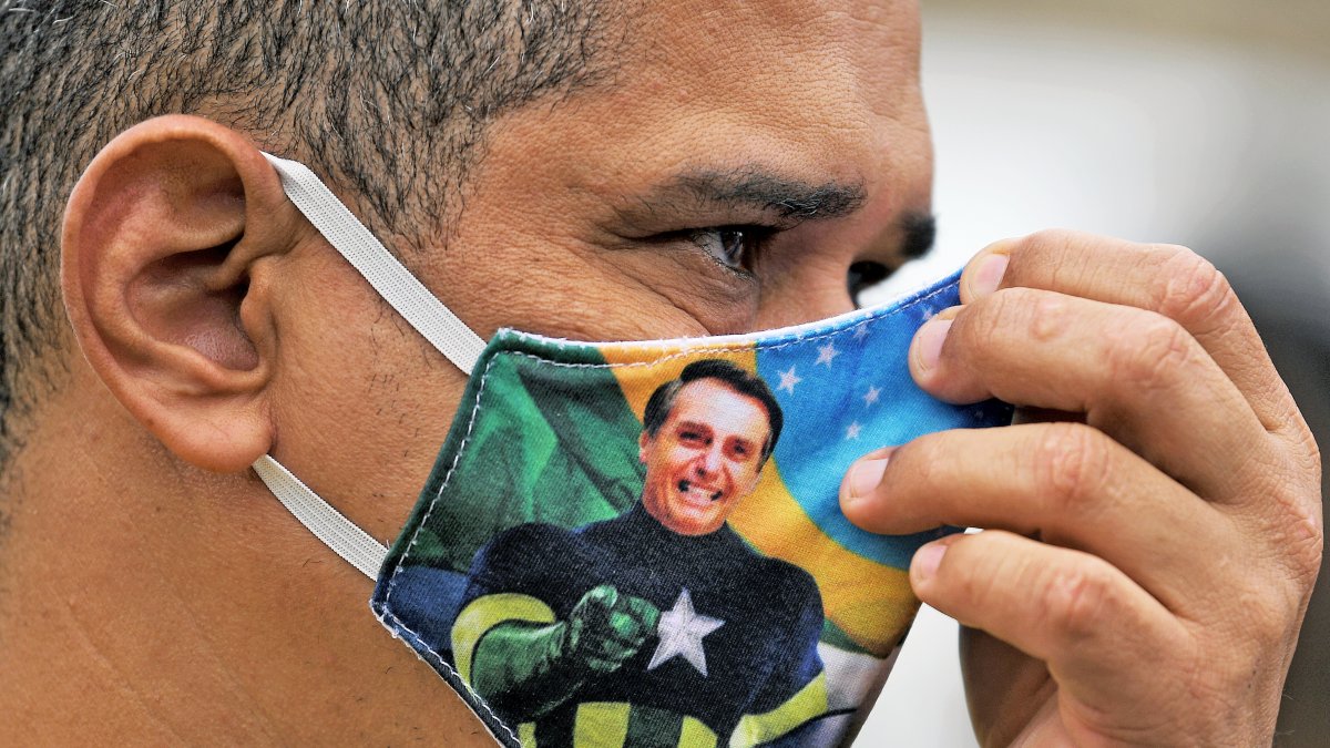 Un seguidor de Bolsonaro porta una mascarilla en la que el rostro del presidente de Brasil aparece con el cuerpo del personaje 'Capitán América'.