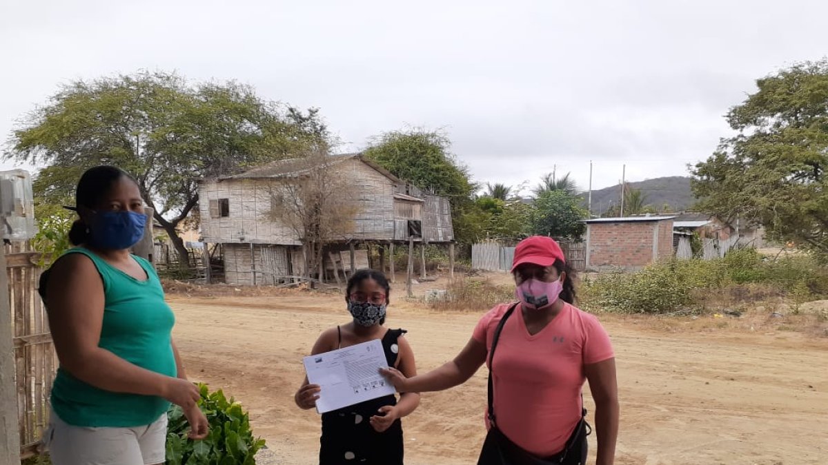 La profesora Rocío Ureta entrega las fichas pedagógicas a uno de sus alumnos en la zona rural del cantón Sucre, Manabí.