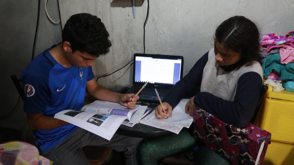 En la cooperativa de vivienda Sergio Toral, del noroeste de Guayaquil, dos hermanos comparten una computadora para sus clases.