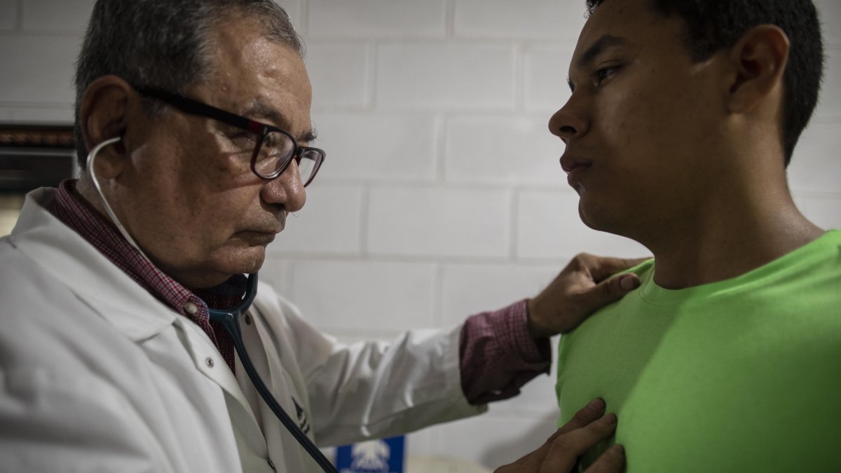 Gustavo Méndez revisa a un paciente en su casa, tras su salida del hospital Manuel de Jesús Rivera.