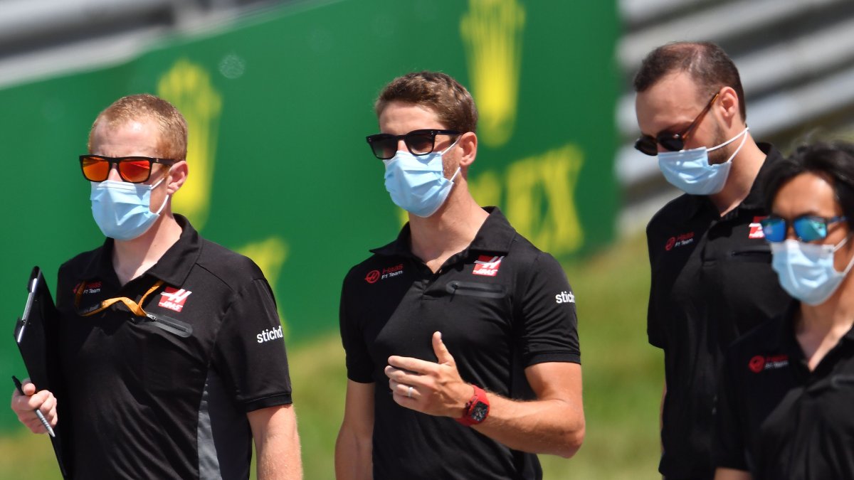 Algunos integrantes del equipo Haas, con el piloto francés Romain Grosjean (c), con las protecciones del caso en el circuito de Austria.