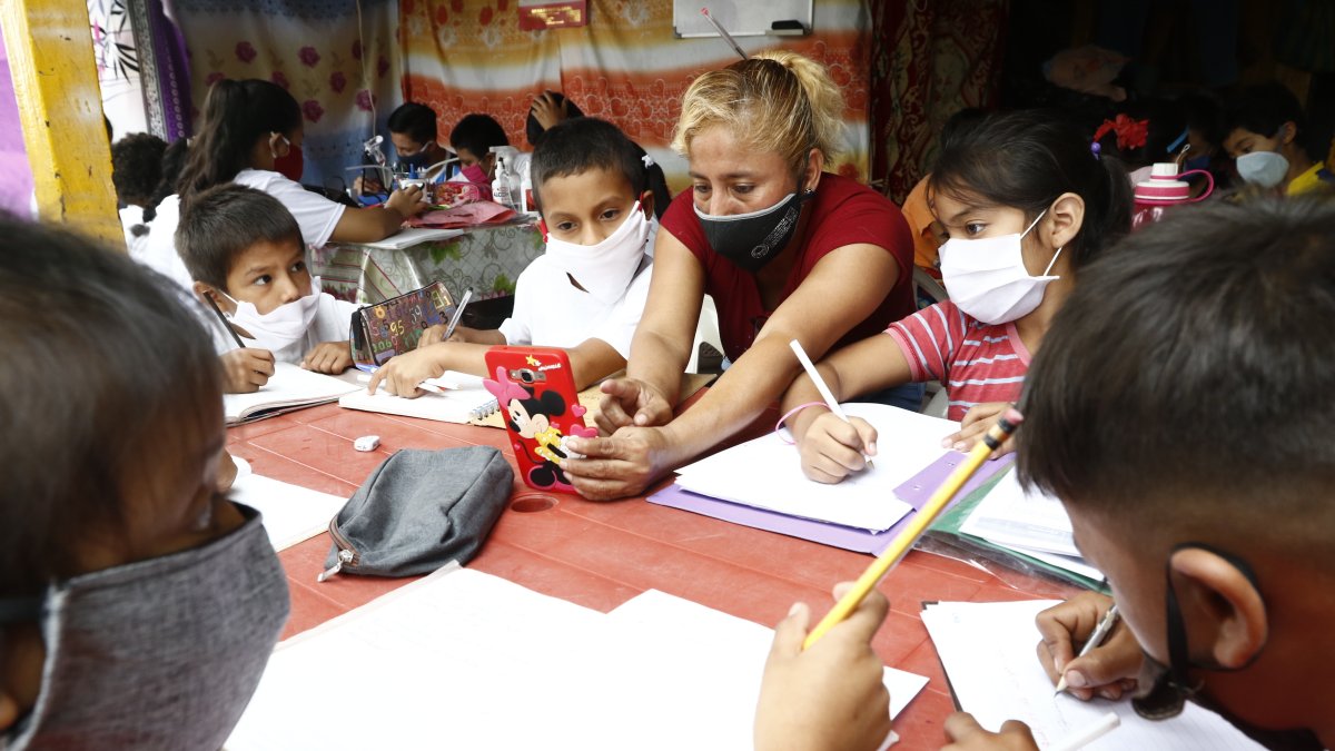 1. Bachita. De lunes a viernes, Beatriz Menoscal ayuda a los niños de la cooperativa Janeth Toral 2 a desarrollar las tareas escolares. Lo hace con la ayuda de su teléfono celular.