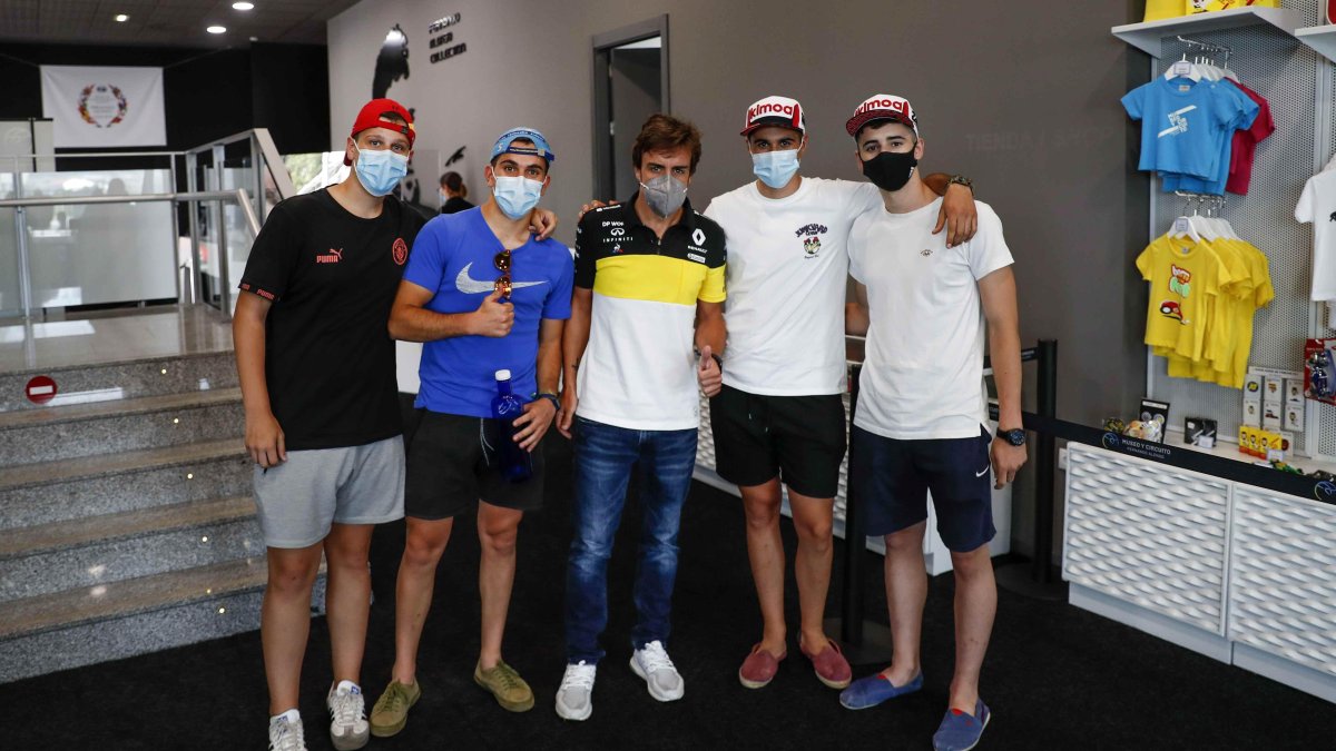 El piloto Fernando Alonso (c) posa con un grupo de aficionados este miércoles en el museo que tiene en el municipio asturiano de Llanera.