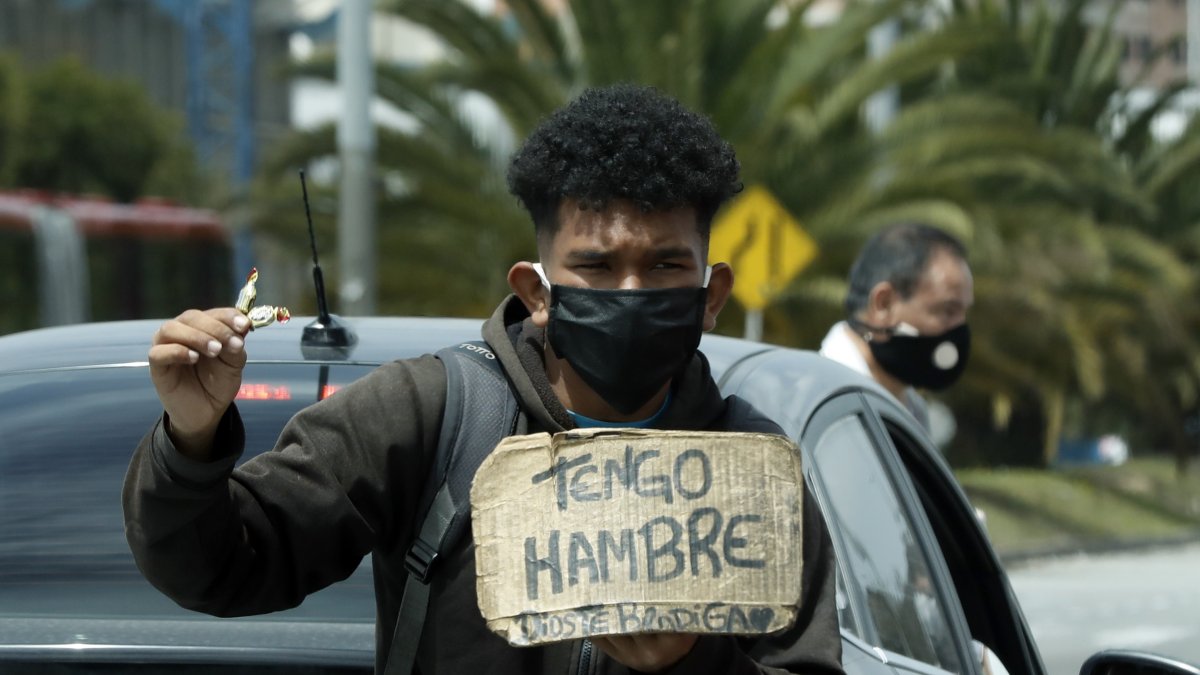 Un hombre vende dulces y pide ayuda en un semáforo en Bogotá, Colombia