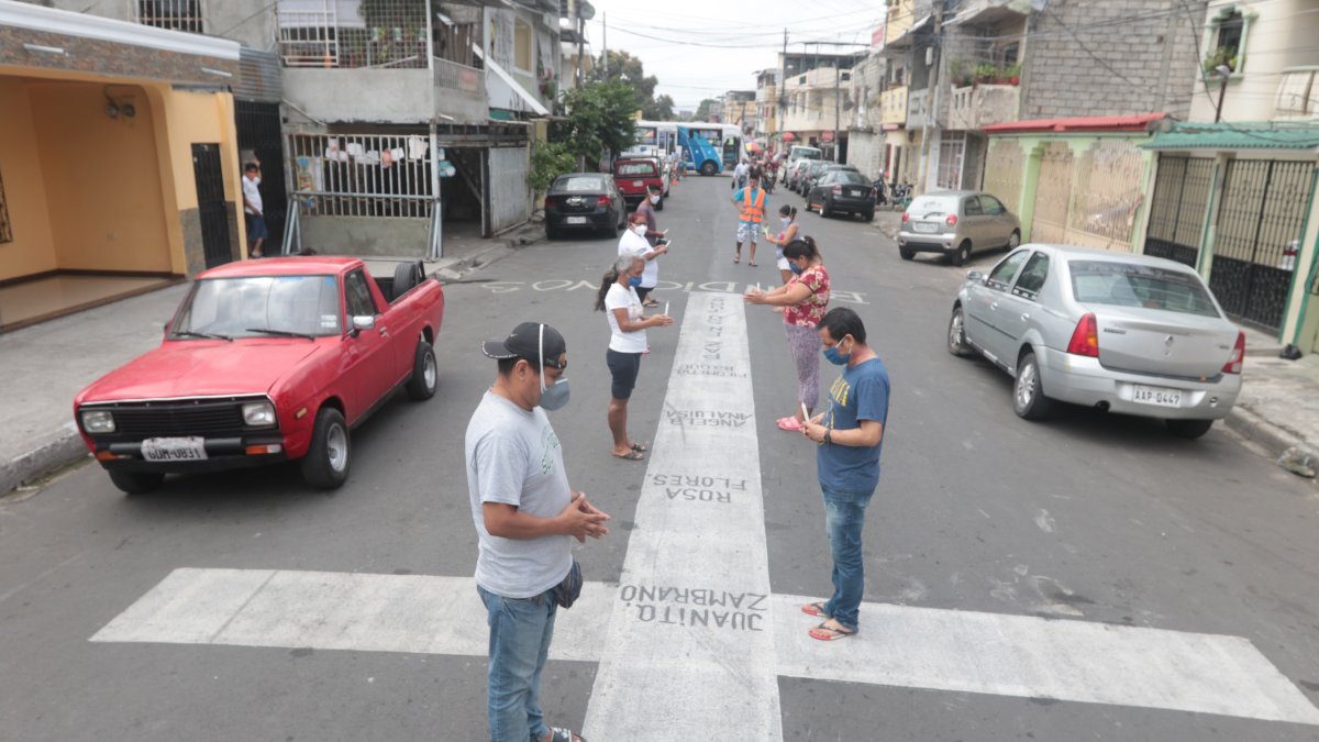 Los vecinos del suburbio rezan alrededor de las cruces, por los fallecidos por COVID-19