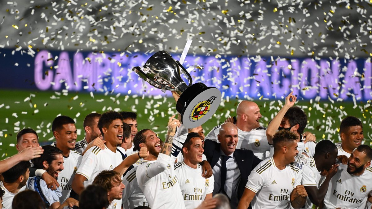 Los jugadores del Real Madrid levantan el trofeo luego consagrarse campeones.
