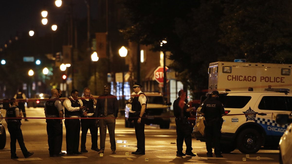 Policías investigan la escena de un tiroteo frente a Rhodes Funeral Service en Chicago.