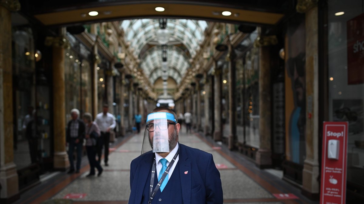 LEED. Un guardia de un área comercial de esta ciudad inglesa, se protege todo el rostro, mientras Inglaterra se prepara para hacer obligatorio el uso de cubiertas faciales en las tiendas.