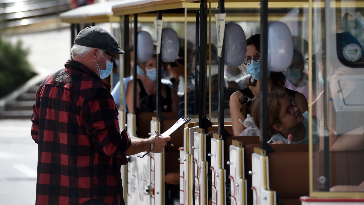 El coronavirus ha obligado a la humanidad a cambiar su estilo de vida. El uso diario de la mascarilla es prueba de ello, como estas personas en Biarritz, Francia.