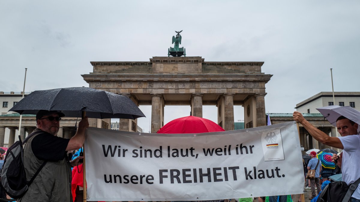 Protestantes en Berlín exponen un cartel que lee: 
