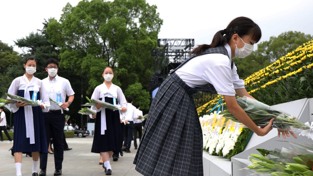 Jóvenes depositan ofrendas en honor a los fallecidos de la bomba de Hiroshima en el Parque de la Paz de la ciudad.