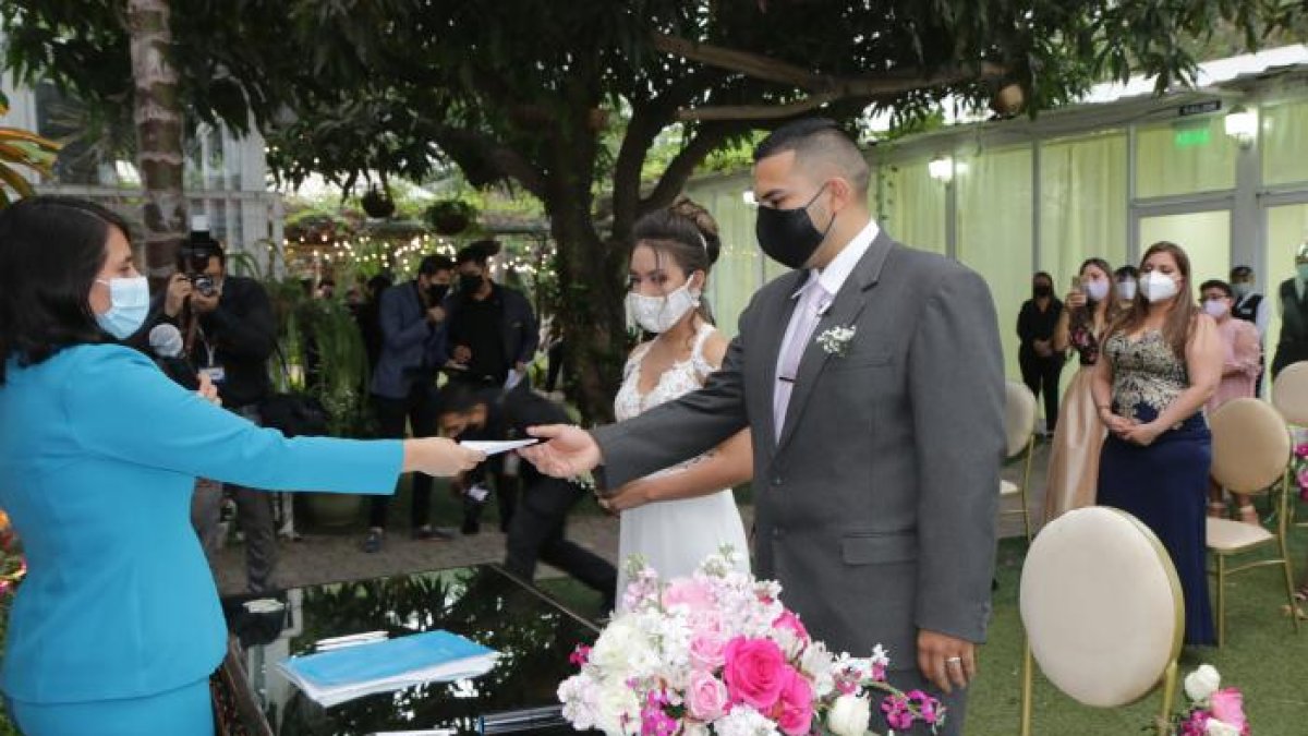 Sofía Cruz, jefa de Matrimonio de la corporación Registro Civil de Guayaquil, entrega el certificado de casados a Daniel Toaza y Nicolle Torres, en una boda a domicilio que se dio en el pasado julio.