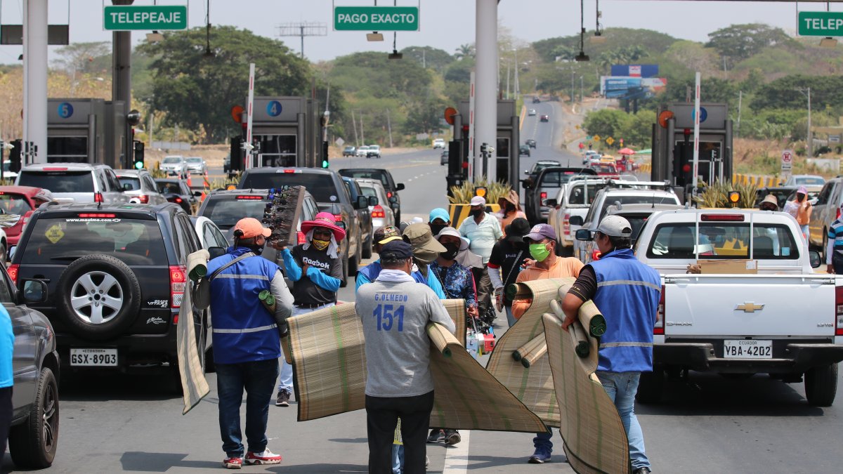 Los vendedores ambulantes promocionan sus productos a los viajeros que cruzan el peaje.