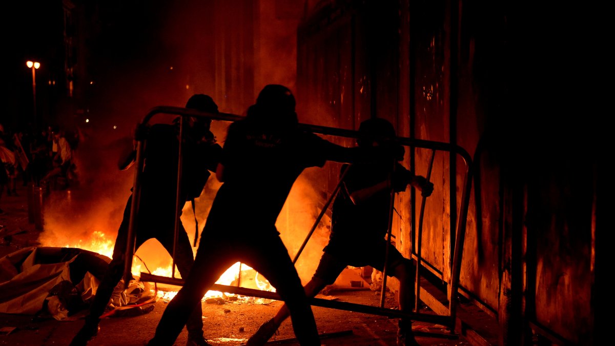 Manifestantes libaneses ntentaban este domingo abrirse paso, a través de una barrera colocada por la policía, para bloquear una carretera que conduce al edificio del Parlamento.